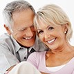 Senior couple smiling together after periodontal therapy
