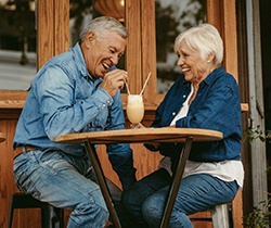 Senior couple with dentures in State College sharing a milkshake