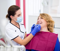dentist looking at patient’s mouth 