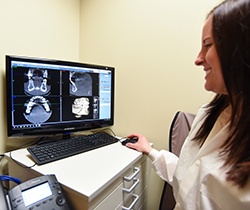 Dental team member reviewing 3D cone beam scan images