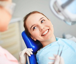 Smiling woman with metal free dental restorations in dental chair