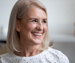 woman smiling after getting dentures in State College