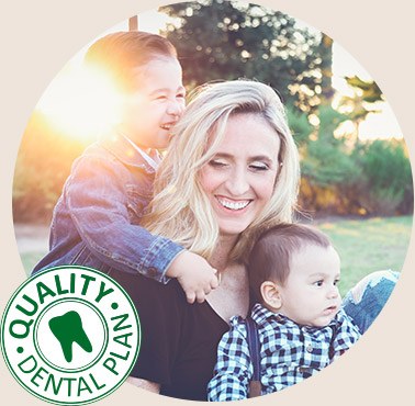 Mother and two children smiling outdoors