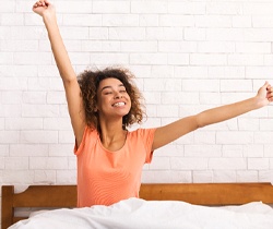 Woman waking up well-rested thanks to myofunctional therapy