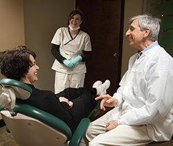 Doctor Marks smiling at patient during preventive dentistry checkup and teeth cleaning