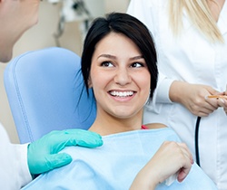 Smiling woman at dental office for oral cancer screening