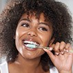 Woman brushing teeth representing preventive dentistry
