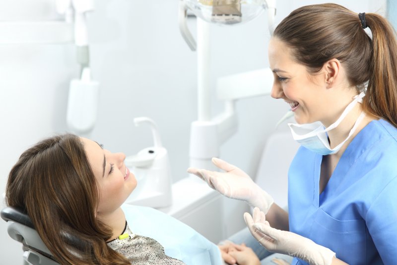 Dentist smiling while talking to patient