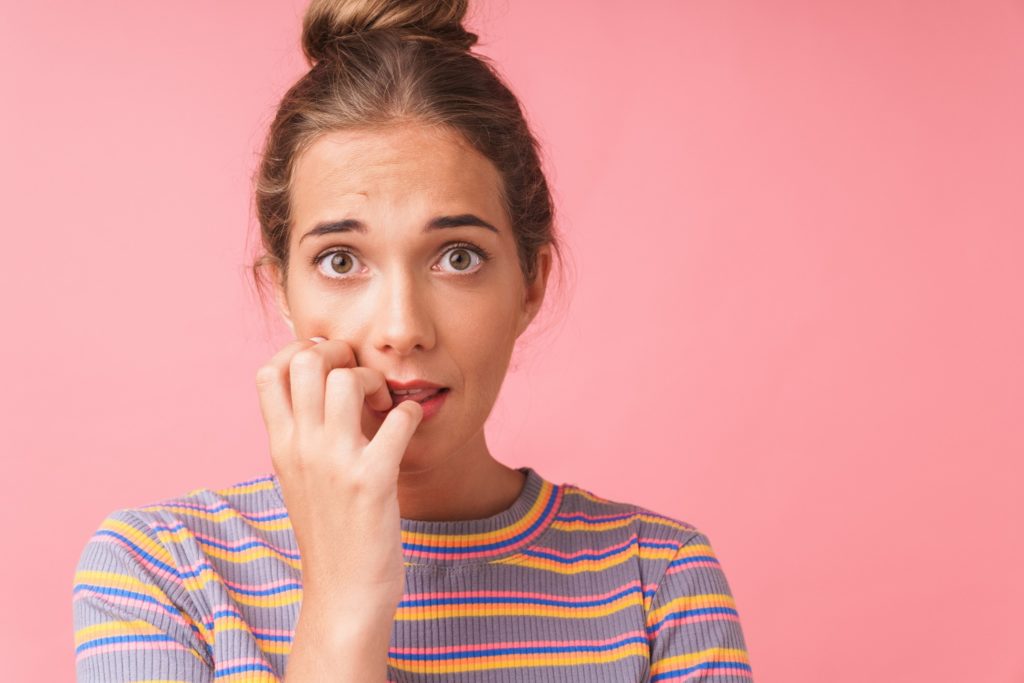 Woman looking concerned and biting her nails