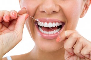 smiling woman flossing her teeth
