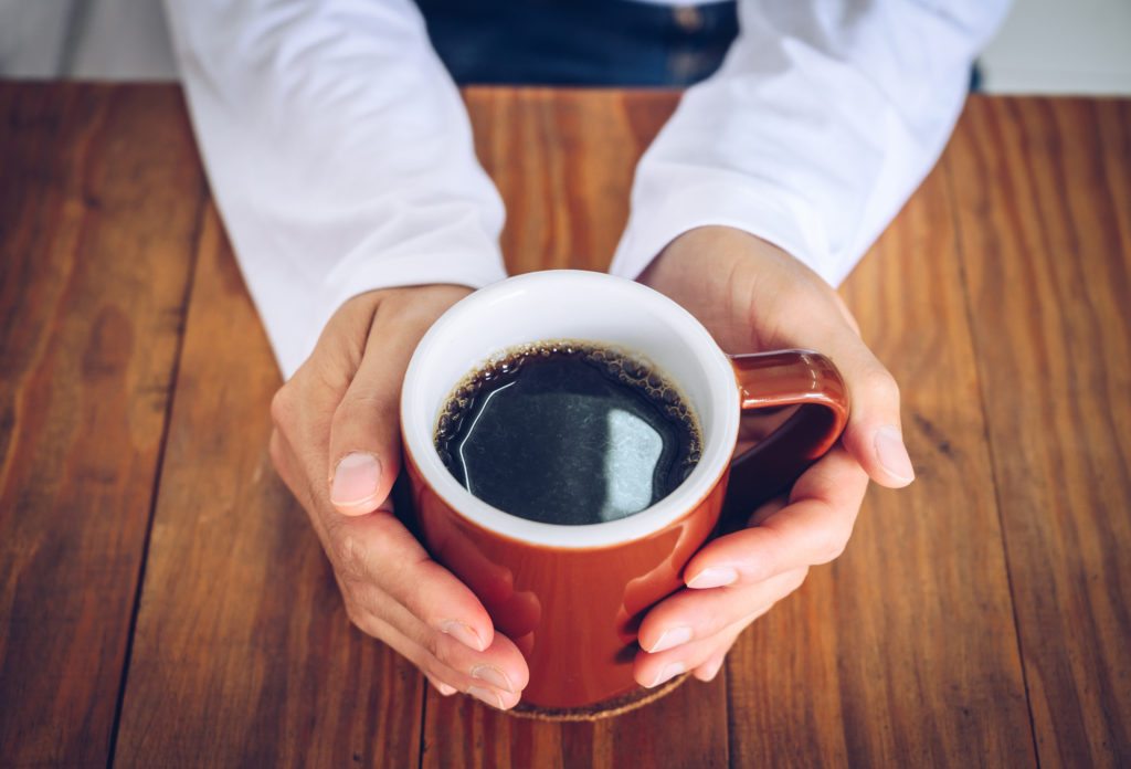 hands holding cup of coffee