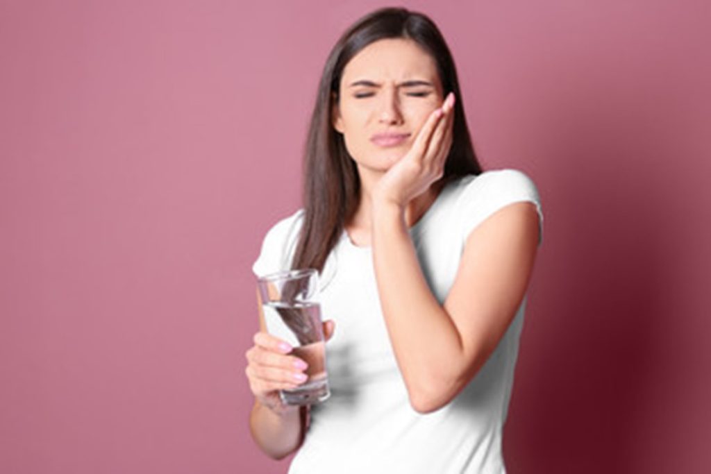 Woman experiencing mouth sensitivity.